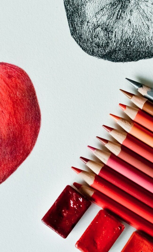 red apple fruit beside black and white pen