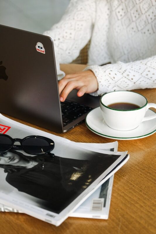 A woman sitting at a table using a laptop computer